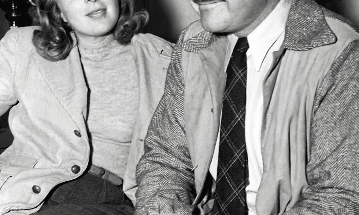 Ernest Hemingway i jego żona Mary Welsh siedzą blisko siebie, ona uśmiecha się lekko.