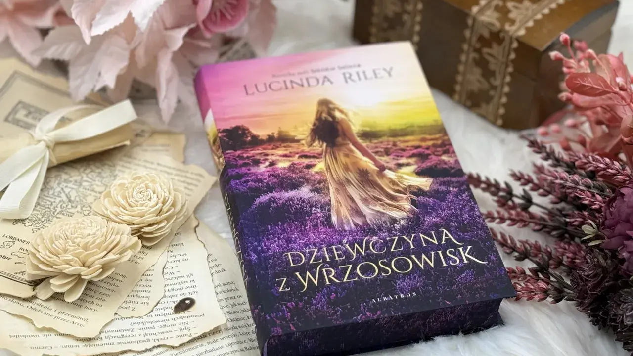 Dziewczyna z wrzosowisk, otoczona starymi księgami i kwiatami, zaprasza do świata pełnego tajemnic i przygód.