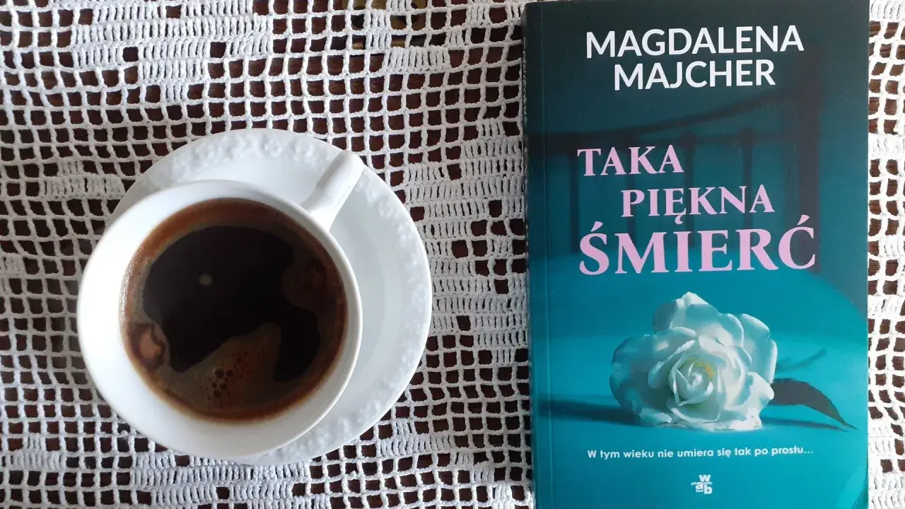 Kawa i książka Magdaleny Majcher "Taka piękna śmierć" na białej serwetce.