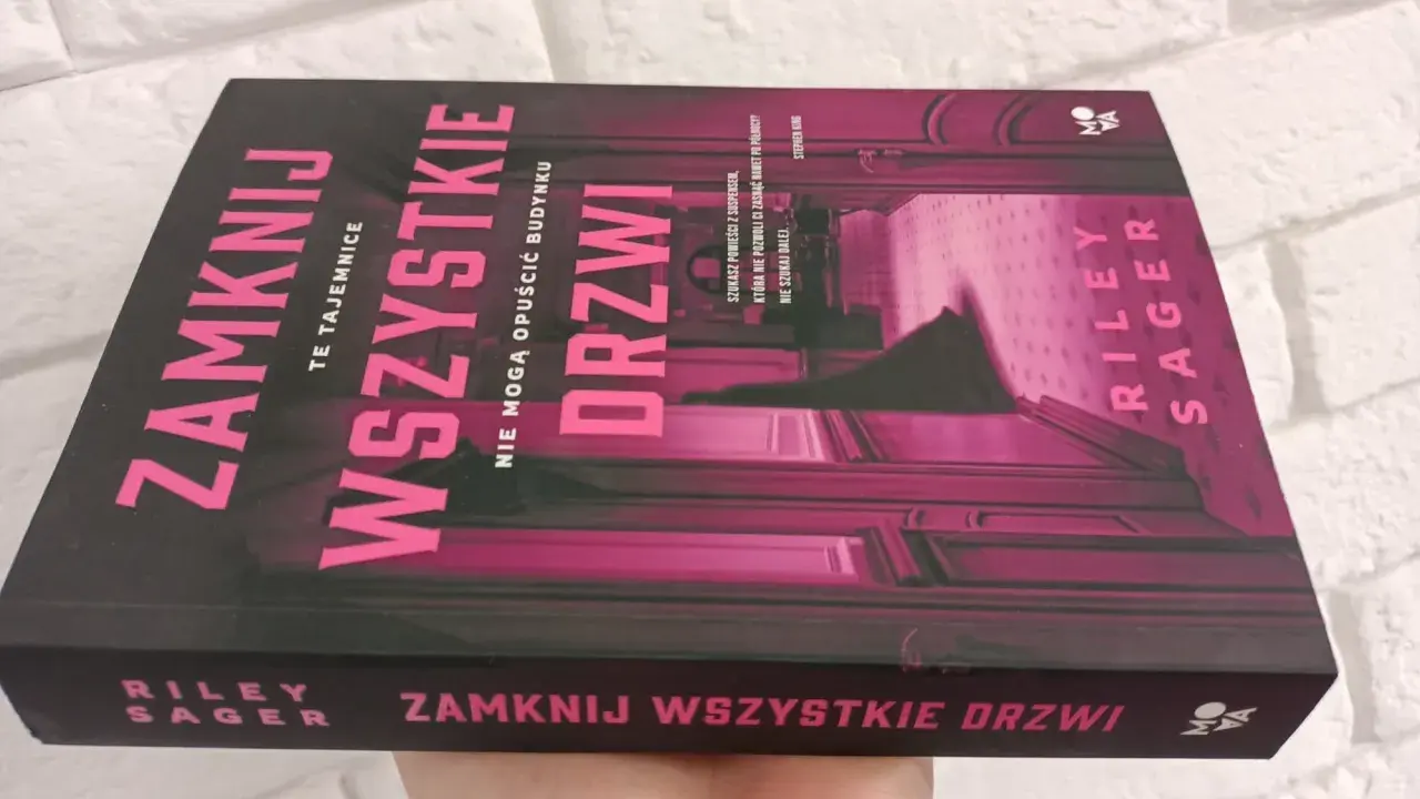 Okładka książki "Zamknij wszystkie drzwi" z różowymi neonowymi literami na czarnym tle.