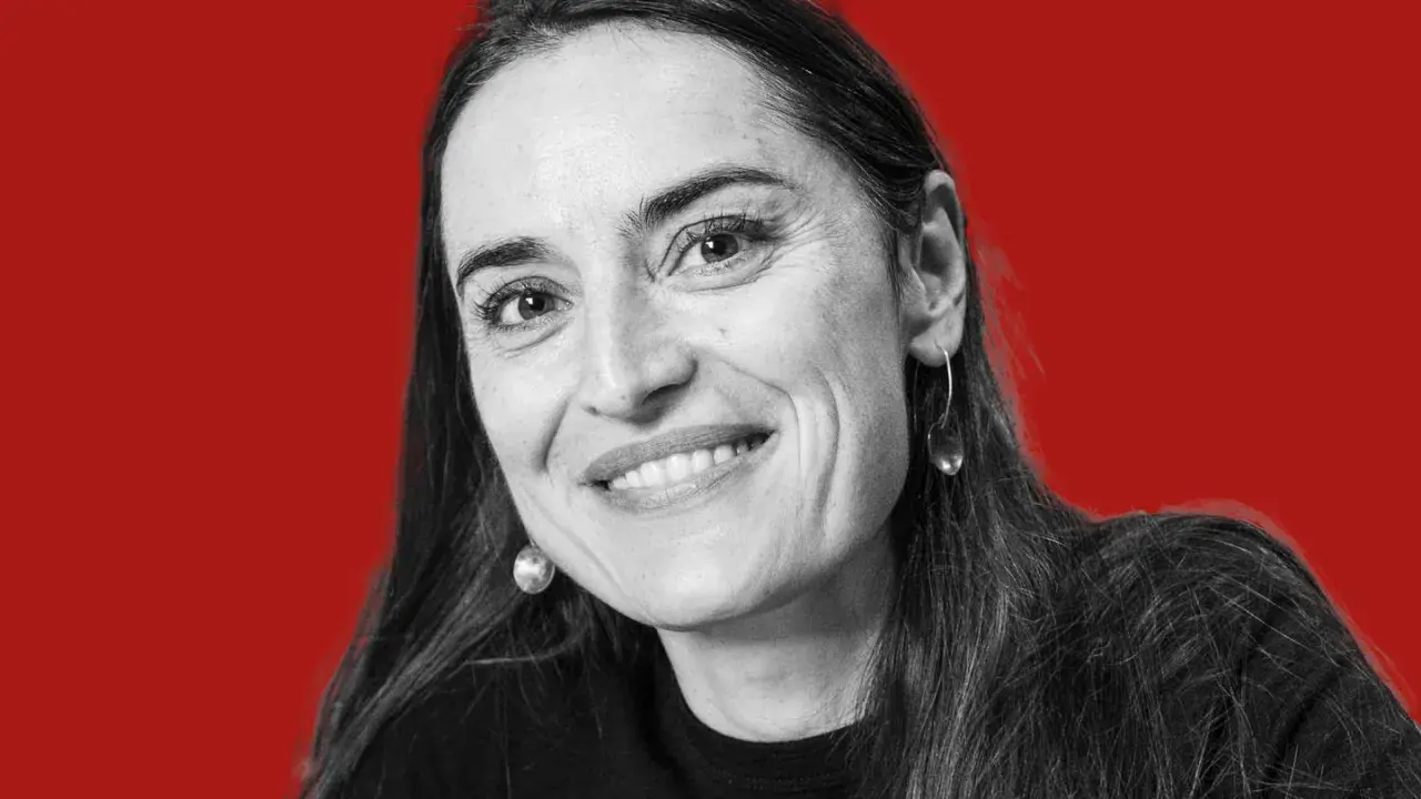 Uśmiechnięta kobieta z długimi włosami, w czarnej bluzce, z okrągłymi kolczykami. Mówi: "nie jestem twoim polakiem".