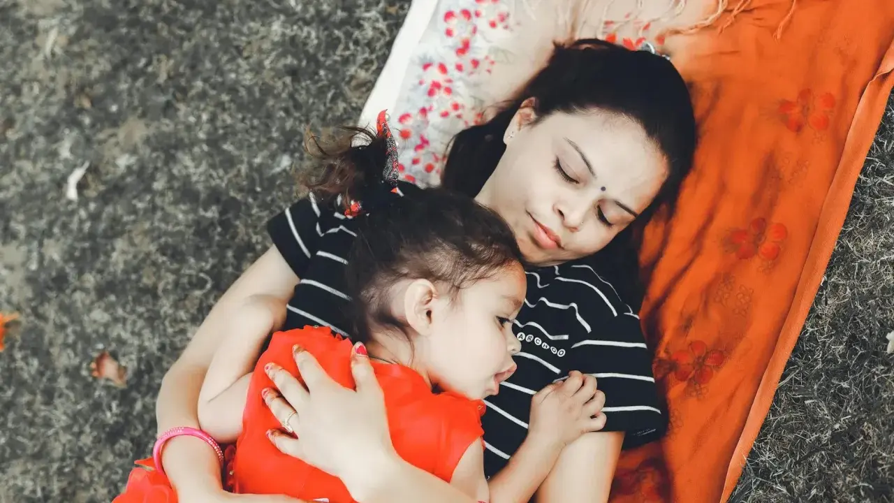 Mama i dziecko leżą przytuleni, uosabiając sztukę prostego życia. Ich spokój i bliskość to najpiękniejszy obraz.
