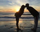 Para, całująca się na plaży o zachodzie słońca. Ich miłość to jedna z tych opowieści o tym, co w życiu ważne.