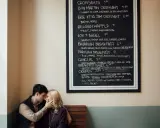 Para zakochanych przy tablicy z menu kawiarni.