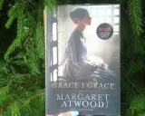 Okładka książki "Grace i Grace" Margaret Atwood, z kobietą w tle i logo Netflix.