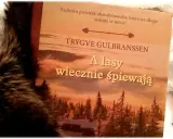 Okładka książki "A lasy wiecznie śpiewają" Trygve Gulbranssena, otoczona miękkim futrem.