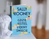 Biała rzeźba popiersia obok książki Sally Rooney "Gdzie jesteś, piękny świecie".
