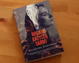 Okładka książki "Nocami krzyczą sarny" z czaszką sarny i twarzą kobiety. Tajemnicza historia o rodzinnych sekretach.
