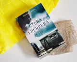 Okładka książki "Czern i Purpura" z pociągiem i sylwetką kobiety.