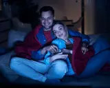 Para spędza miły wieczór, otulona kocem, oglądając lekkie filmy na wieczór i jedząc popcorn.