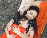 Mama i dziecko leżą przytuleni, uosabiając sztukę prostego życia. Ich spokój i bliskość to najpiękniejszy obraz.