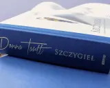 Granatowa okładka książki "Szczygieł" Donny Tartt z wytłoczonym złotym napisem.