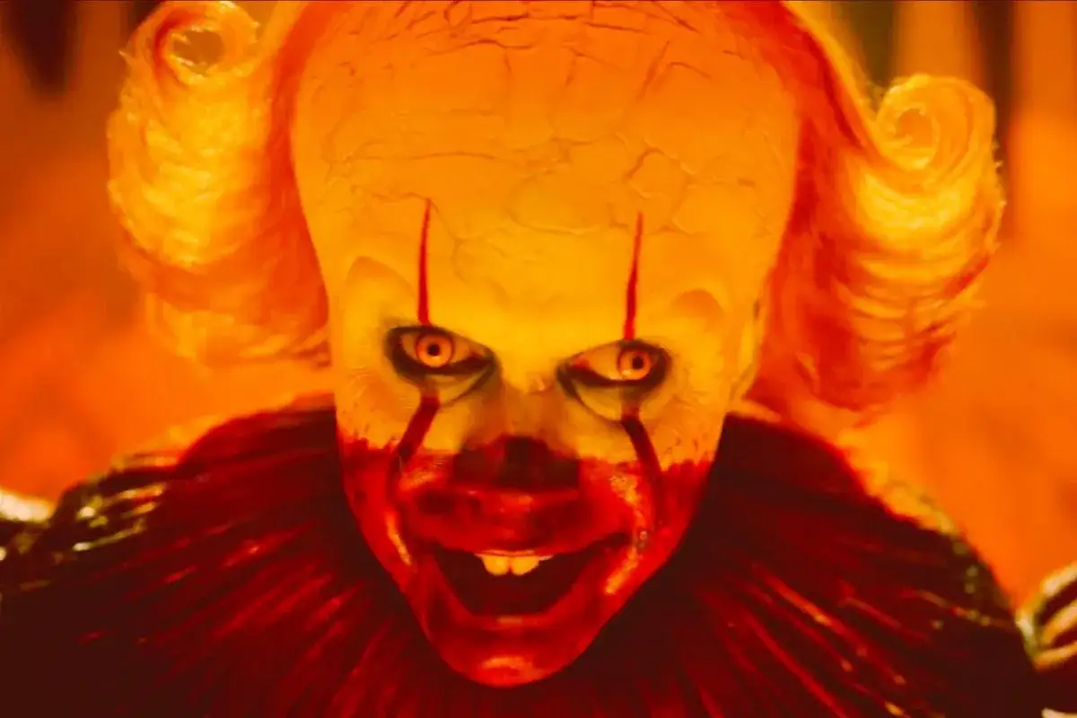 Przerażający klaun Pennywise z krwawiącymi oczami i uśmiechem zaprasza do Derry.